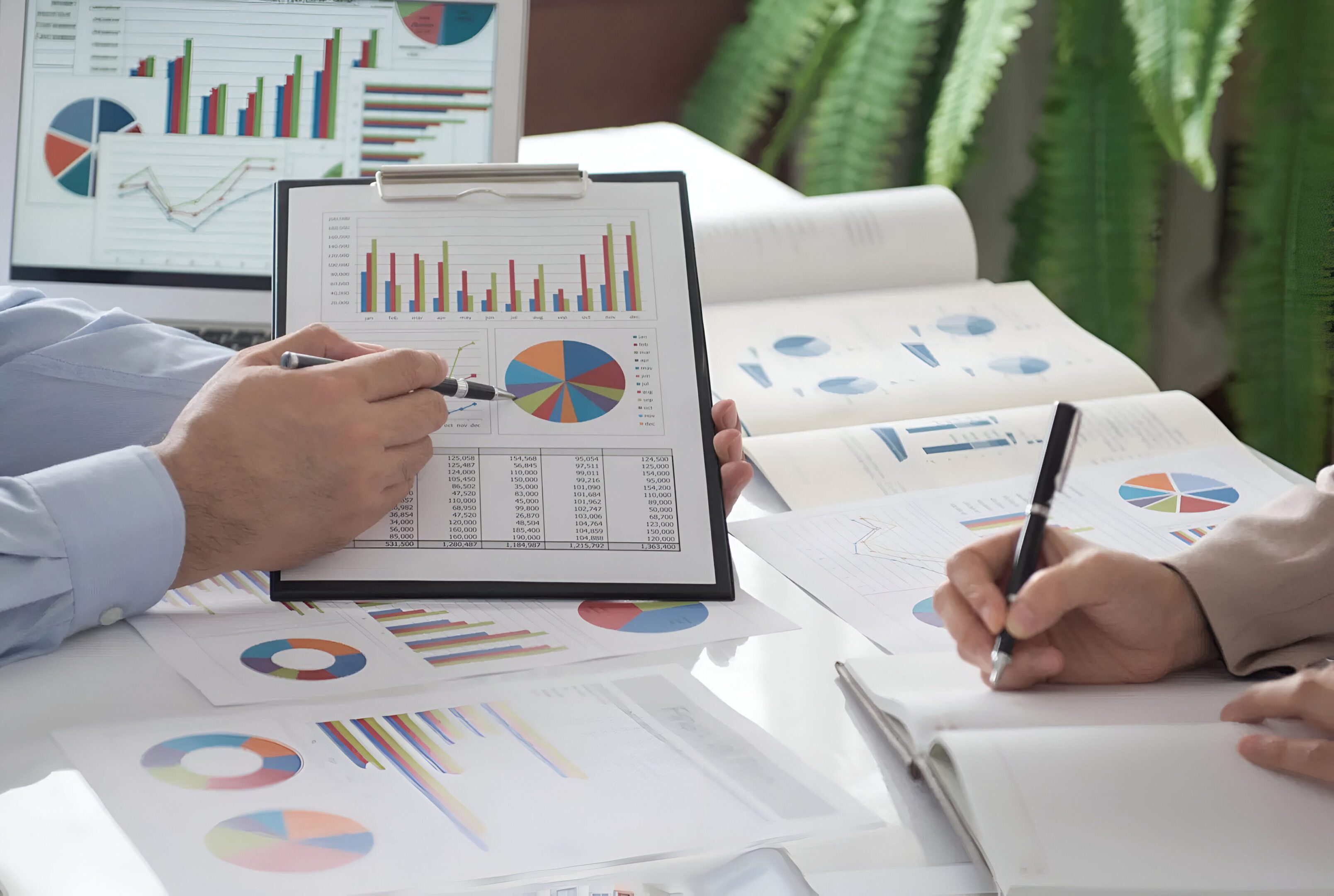 pixelcut-export (30) Businesspeople reviewing financial charts and graphs.